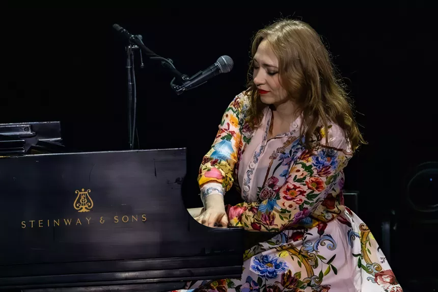 A woman singing on a piano