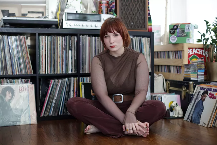 Woman sitting down in front of vinyls