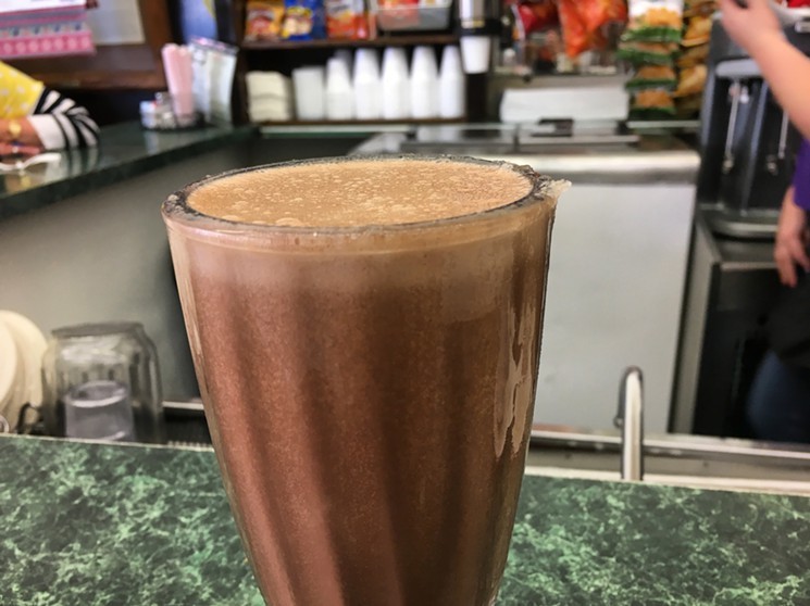 The egg cream, bubbly with soda water and creamy with chocolate syrup, served in an frosted sundae glass at Highland Park Soda Fountain. - NICK RALLO