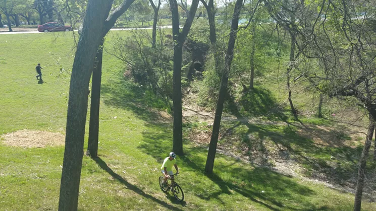 The drainage tunnel where Anthony Green lived (top, center) can’t be seen by those walking down the incline to Oak Cliff Founders Park. - JOE PAPPALARDO