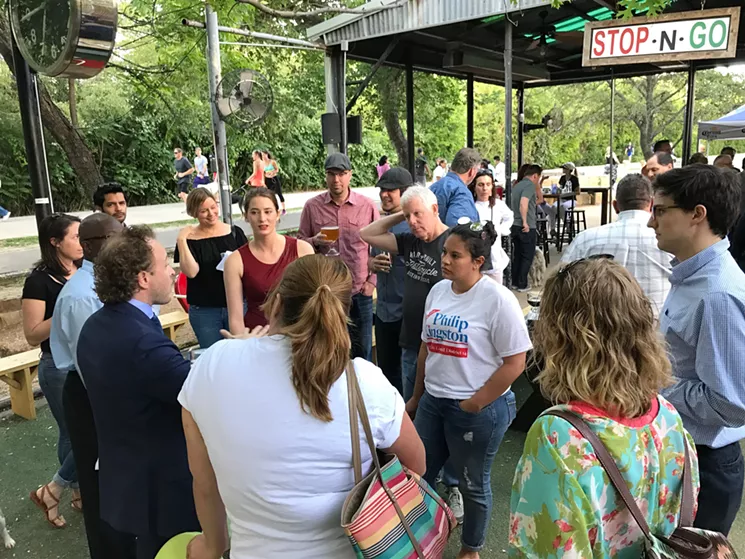 Michelle Espinal, wearing a white Philip Kingston T-shirt, engaged in debate with Matt Wood's supporters at Monday night's Save the Patio event at Katy Trail Ice House. - BETH RANKIN