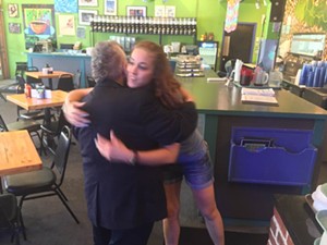 Courtney Ledesma, a waitress who works at Cafe Brazil in Deep Ellum, gives Keyboard Bob Crawford a hug. - DANNY GALLAGHER