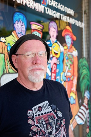 Warren Lunt stands in front of his recently commissioned work — a Beatles window sign for Atomic Candy in Denton. - SARAH SCHUMACHER