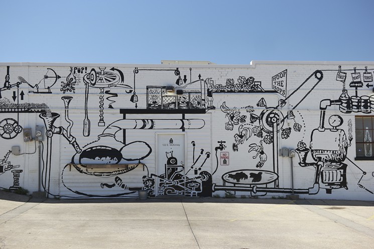 A section of Warren Lunt's Rube Goldberg-esque mural design, painted by volunteers, on the side wall of Denton's Bearded Monk shop. - SARAH SCHUMACHER