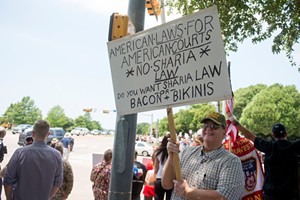 Demonstrators held signs in a march against Sharia. - BRIAN MASCHINO
