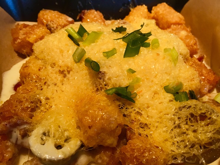 Green onions, finely grated cheddar and fontina cheese sauce cover tater tots in Deep Ellum's Hide. - NICK RALLO