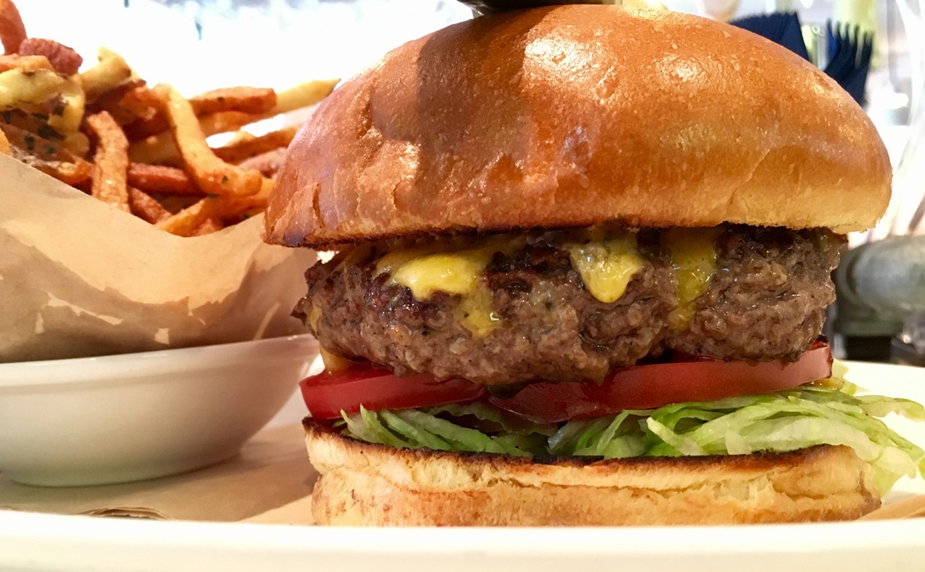 The $17 lunch burger at Montlake Cut, with Tillamook cheddar, lettuce, tomato and onion sliced paper thin.