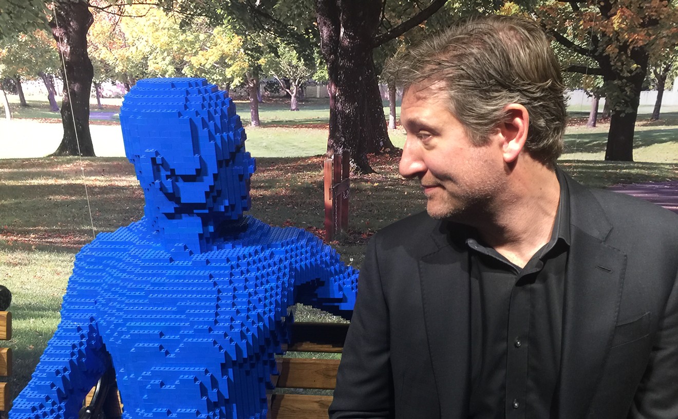 Artist Nathan Sawaya sits next to one of his "Park People" sculptures made entirely out of LEGO building blocks. It's part of the traveling art exhibit The Art of the Brick. The exhibition opened Saturday at the Perot Museum of Nature and Science.