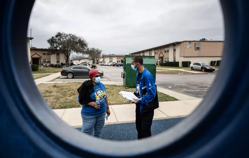 Community organizer Ryan Ahmadian talks to a resident in Estelle Village, where tenants complain of unfair treatment and poor maintenance.