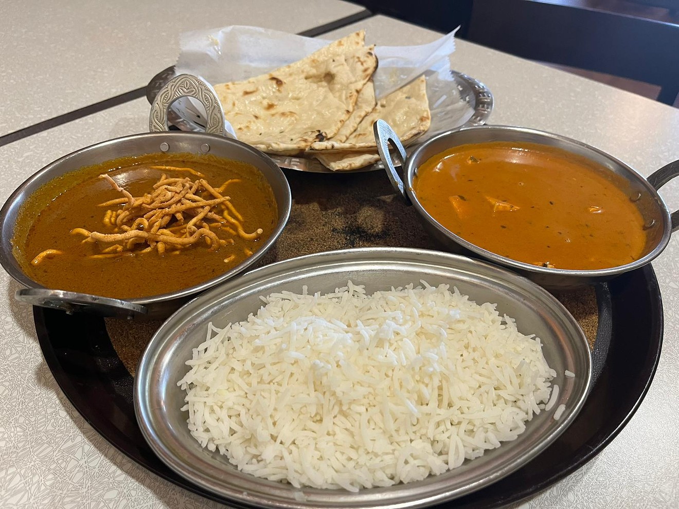 Curry options include a zesty butter paneer and a sev bhaji, with a crunchy flour-based topping. All curries come with a side of rice.