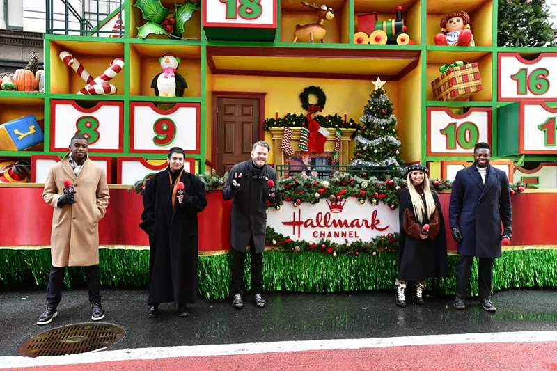 Image: Pentatonix members Matt Sallee, Mitch Grassi, Scott Hoying, Kirstin Maldonado, and Kevin Olusola pose in front of the Hallmark float at the 2020 Macy's Thanksgiving parade.