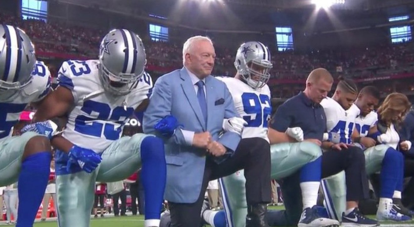 Jerry Jones kneels with his players before the Dallas Cowboys game against the Arizona Cardinals.