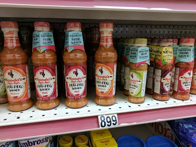 Image: One of the several shelves of different piri-piri sauces at Quick Shop.