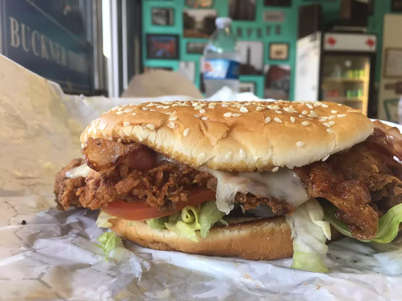 Image: A fried chicken sandwich on a smashed sesame bun at Harvey B's, with Swiss cheese and bacon for less than $6.