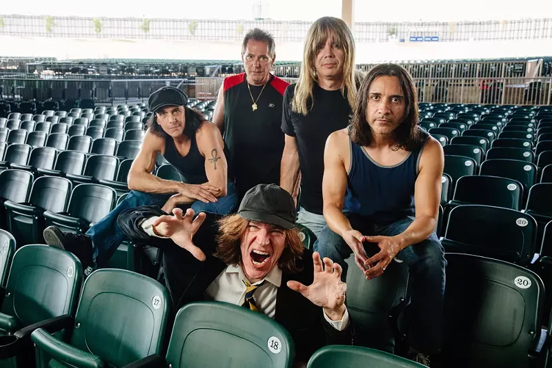 Image: Mike Mroz (front) leads the AC/DC tribute band, Back in Black, in Dallas. His band members include (back, from left) Darren Caperna on vocals, Ken Schiumo on drums, Sheldon Conrad on bass and Ramiro Noriega on guitar.
