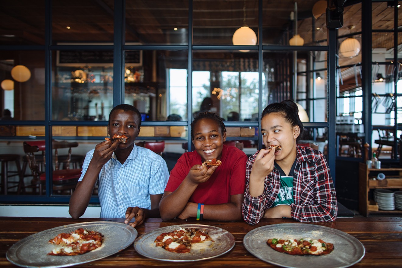 From left: Moise, Mariam and Pay Pay enjoy the fruits of their labor after learning how to make pizza at Eno's as part of the International Rescue Committee's Youth Food Justice internship.