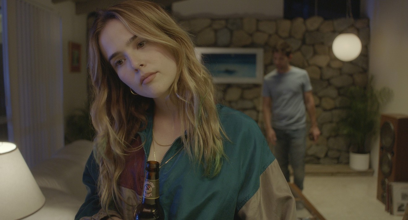 In Flower, Zoey Deutch (foreground) plays Erica, a troubled teen acting on instinct who makes it her mission to blackmail a teacher (Adam Scott) in order to make her stepbrother feel better.